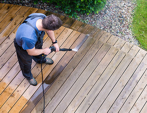 Contractor power washing a deck in preparation for restaining. Contractor power washing a deck in preparation for restaining.